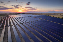 Aerial Top View Of A Solar Power Plant With Sunset Reflection On The Solar Panels. Solar Park Is A Ground-mounted Solar Project Which The Company Installed 138.000 Solar Panels In Spain