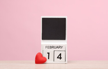 Wall Mural - Valentine's Day. Block calendar with the date February 14 on pink background with heart. Love romantic concept