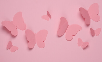 Wall Mural - Butterflies cut out of paper on a pink background. Spring background