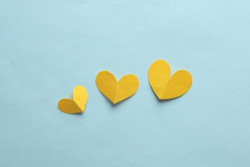 Wall Mural - Paper-cut yellow hearts on blue background. Love concept