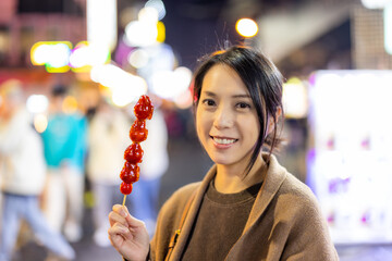 Wall Mural - Woman hold with Tanghulu traditional Chinese hard caramel coated strawberry skewer