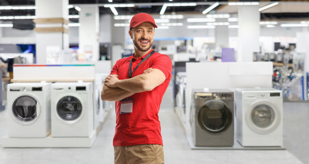 Wall Mural - Sales manager posing inside an electrical appliance shop with washing machine