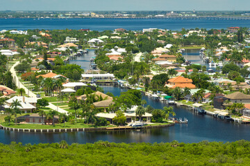 Wall Mural - Aerial view of rural private houses in remote suburbs located on sea coast near Florida wildlife wetlands with green vegetation on gulf bay shore. Living close to nature in tropical region concept