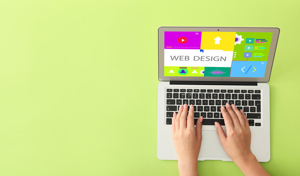 Hands of web designer with laptop on green background with space for text