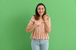 © Pixel-Shot - Young woman pointing at stylish wristwatch on green background