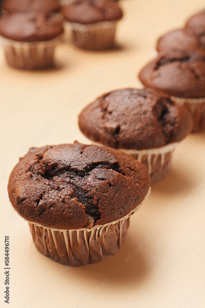 Tasty chocolate cupcakes on beige background