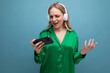 © Ivan Traimak - cute enthusiastic attractive blonde girl with headphones and smartphone on blue background