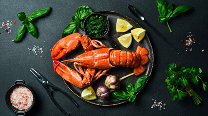 Wall Mural - Luxurious boiled spiny lobster with spices, basil and lemon on a black stone plate. Free space for text.