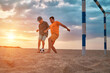 © Andrii IURLOV - Happy family outdoors, Father and Son playing football, family fun players in soccer in dynamic action have fun playing football in the beach, summer day under sunlight.