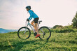 © Andrii IURLOV - Cyclist Woman riding bike go in sports outdoors on sunny day a mountain in the forest. Silhouette female at sunset. Fresh air. Health care, authenticity, sense of balance and calmness.