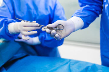 Wall Mural - Low Angle Shot in the Operating Room, Assistant Hands out Instruments to Surgeons During Operation. Surgeons Perform Operation. Professional Medical Doctors Performing Surgery.