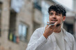 © carballo - young man in the street with phone sending voice message or recording audio