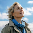 © nenetus - Beautiful mature woman looking for the horizon while relaxing in nature. Generative AI