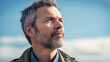 © nenetus - Handsome mature man looking for the horizon while relaxing in the nature. Generative AI