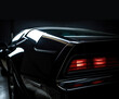 © J S - Stylish rear left side corner of a black  1970s muscle sports car with close-up of a red rear light illuminated; dark studio shot with copy space in shadows, generative ai