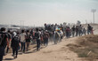 Illustration of mass immigration of people, the concept of social problems. Large group of refugees walking on a dusty road, representing the mass movement and challenges they face.