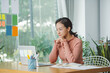 © Marc Tran/Stocksy - Pretty cute woman sitting at the table working with computer