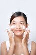 © Marc Tran/Stocksy - Happy woman with fresh perfect skin applying foaming cleanser