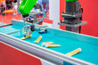 Pick and place robotic arm manipulator with suction cups moves and lifts hand cream tubes at modern robot exhibition, trade show