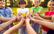 © Studio Romantic - Happy children joining hands and giving thumbs up together. Croup of boys and girls standing in circle showing thumb up gesture expressing positivity. Unity, teamwork, success concept