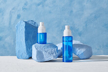 Bottles Of Organic Cosmetic Products Blue Stones On Color Background