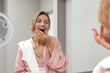 © Demetr White/Stocksy - Woman taking dental retainer off