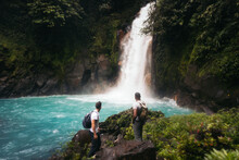 Friends Visiting The Rio Celeste Waterfall In Costa Rica