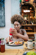 © Daniel Gonzalez/Stocksy - Cuban woman adding ketchup to burger