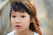 © ChaoShu Li/Stocksy - Little Asian girl expression blown by the wind, street
