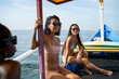 © Jovo Jovanovic/Stocksy - Happy girl friends relaxing on wooden boat sailing the ocean