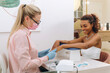 © Alina Hvostikova/Stocksy - Smiling black woman getting manicure