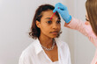 © Alina Hvostikova/Stocksy - Crop beautician plucking eyebrows with tweezers