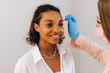 © Alina Hvostikova/Stocksy - Crop beautician plucking eyebrows with tweezers