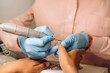 © Alina Hvostikova/Stocksy - Master polishing nails of client in salon