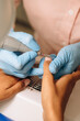 © Alina Hvostikova/Stocksy - Master polishing nails of client in salon