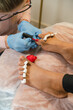 © Alina Hvostikova/Stocksy - Crop pedicurist applying nail polish