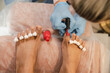 © Alina Hvostikova/Stocksy - Crop pedicurist applying nail polish