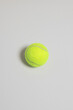 © Malin G/Stocksy - Neon tennis ball on a grey background