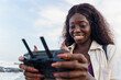 © Jovo Jovanovic/Stocksy - Woman holding a remote control of a drone at the beach