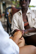 © Jovo Jovanovic/Stocksy - Woman sitting on an outdoor chair holding her friend's hand