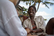 © Jovo Jovanovic/Stocksy - Woman sitting on an outdoor chair holding her friend's hand