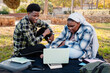 © Lucas Ottone/Stocksy - Black students sitting with laptop in a park