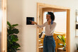 © BONNINSTUDIO/Stocksy - Woman using device in smart home