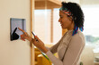© BONNINSTUDIO/Stocksy - Woman using device in smart home