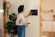 © BONNINSTUDIO/Stocksy - Woman using device in smart home