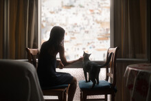Woman Caressing Cat Near The Window