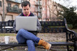 © Lupe Rodríguez/Stocksy - Young man with down syndrome with a laptop in a park