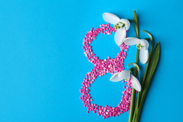 Wall Mural - Beautiful snowdrops and number 8 made of decorative mosaic stones on light blue background, flat lay. Space for text