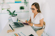 © Olga Moreira/Stocksy - Female freelancer working at her desk at home office