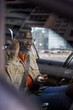© Jovo Jovanovic/Stocksy - Male driver inserting earphones into ear while sitting in the car